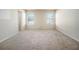 Spacious bedroom with neutral walls, carpeted floor and two windows at 412 Vermeer Ct, Locust Grove, GA 30248