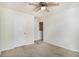 Bedroom features neutral carpet, a ceiling fan with light, closet, and light-colored walls at 412 Vermeer Ct, Locust Grove, GA 30248