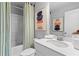 Bright bathroom with fresh white finishes, a shower-tub combo, and contemporary artwork at 8214 Tiger Way, Riverdale, GA 30274