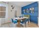 Dining area featuring modern table with blue chairs and a large window at 8214 Tiger Way, Riverdale, GA 30296