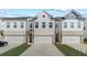 New townhome with a bright white facade and a private two-car garage at 8214 Tiger Way, Riverdale, GA 30296