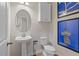 Modern powder room featuring a pedestal sink, elegant wall art, and a toilet at 8214 Tiger Way, Riverdale, GA 30274