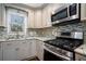 Close-up of kitchen details including stainless steel stove, microwave, sink, backsplash, granite countertops, and cabinetry at 4811 Warners Trl, Norcross, GA 30093