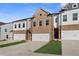 Three-unit townhome building with brick and white siding at 8210 Tiger Way, Riverdale, GA 30274