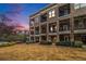 Townhouse exterior at dusk showcasing a brick facade, balconies, and a grassy area at 327 Brownstones Ne Cir, Atlanta, GA 30312