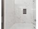 Bathroom with a white bathtub and marble tile surround at 213 Yuba Walk, Lawrenceville, GA 30046