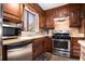 Cozy kitchen boasts stainless steel appliances and classic wood cabinetry at 1491 Stoneleigh Way, Stone Mountain, GA 30088