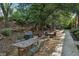 Outdoor seating and grilling area with gravel, mature shade trees and a sidewalk at 195 Arizona Ne Ave # 158, Atlanta, GA 30307