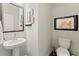 Chic powder room with pedestal sink, toilet, and framed art at 279 Commons Ave, Woodstock, GA 30188