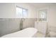 Bathroom with a large soaking tub, gray tile, and white vanity at 2982 Cruse Rd, Lawrenceville, GA 30044