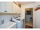 Laundry room with washer, dryer, cabinets, and utility sink at 314 Pepperwood Way, Canton, GA 30114