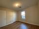 Well-lit bedroom featuring wood-look floors and a window at 8263 Canyon Forge Dr, Riverdale, GA 30274