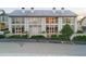 Charming townhome featuring tile roof, large windows, and manicured landscaping at 130 Rolison Way, Fayetteville, GA 30214