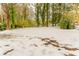 Partially snow-covered backyard with mature trees at 2792 Plantation Dr, Atlanta, GA 30344