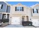 Exterior view of townhome featuring garage, neutral paint, and manicured shrubs at 915 Highwood Ln, Atlanta, GA 30344