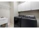 Functional laundry room with sink, washer, dryer, and storage cabinets at 183 Applewood Ln, Acworth, GA 30101