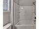 Bathroom features a tub with shower and bright white walls and fixtures at 3353 Pearl Ridge Way, Buford, GA 30519