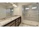Modern bathroom with a granite countertop, dual sinks, and a glass-enclosed shower with light grey tiling at 3353 Pearl Ridge Way, Buford, GA 30519
