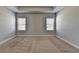Spacious carpeted bedroom featuring two bright windows, with light grey paint, and recessed lighting at 3353 Pearl Ridge Way, Buford, GA 30519