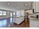 An open kitchen with dark wood floors, an island, stainless steel appliances, and recessed lighting at 3353 Pearl Ridge Way, Buford, GA 30519