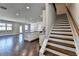 Open Living area with staircase and hardwood floors adjacent to modern kitchen at 3353 Pearl Ridge Way, Buford, GA 30519