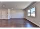 Bright, open living room featuring hardwood floors, crown molding, and a large window for natural light at 3353 Pearl Ridge Way, Buford, GA 30519