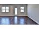 Bright living room featuring hardwood floors, white trim, and a glass door for easy outdoor access at 3353 Pearl Ridge Way, Buford, GA 30519