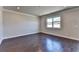 Cozy living space with dark hardwood floors, crown molding, and ample natural light from a large window at 3353 Pearl Ridge Way, Buford, GA 30519