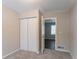 Bedroom with neutral walls, carpeting, double-door closet, and access to another room at 530 Balfour Dr, Decatur, GA 30032