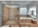 Elegant bathroom featuring glass shower, soaking tub with decorative tile and window at 3204 Woodrow Ne Way, Atlanta, GA 30319