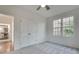 Bright bedroom features neutral carpet, a ceiling fan, closet, and natural light from the window at 3204 Woodrow Ne Way, Atlanta, GA 30319