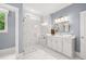 Bright bathroom features a glass shower with marble tile and a white vanity with double sinks and modern lighting at 3709 Tielman St, Snellville, GA 30078