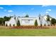 Community entrance features a white brick wall with a sign for Soleil Summit Chase surrounded by grass and red flowers at 3709 Tielman St, Snellville, GA 30078