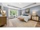 Comfortable main bedroom with tray ceilings, a large window, and a seating area at 3709 Tielman St, Snellville, GA 30078