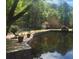 Serene pond with a stone wall and lush greenery at 27306 Plantation Ne Dr, Atlanta, GA 30324