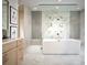 Contemporary bathroom featuring a standalone tub, sleek fixtures, and marble tile at 7170 Pond View Dr, Cumming, GA 30028