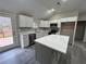 Modern kitchen with white cabinets, a large island, and access to backyard at 10033 Florence Cir, Villa Rica, GA 30180