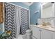 Bathroom with white vanity, shower, and gray chevron curtain at 145 Turning Pt, Stockbridge, GA 30281