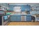 A galley kitchen featuring blue cabinets, stainless steel appliances, and tile flooring at 145 Turning Pt, Stockbridge, GA 30281