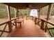 Covered deck with wooden table and view of woods at 3780 Hutcheson Ferry Rd, Whitesburg, GA 30185