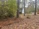 Wooded lot with shed and scattered leaves at 3780 Hutcheson Ferry Rd, Whitesburg, GA 30185