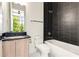 Modern bathroom with dark tile, bathtub, and floating vanity at 192 East Lake Se Ter, Atlanta, GA 30317