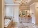 Spa-like bathroom with a large soaking tub, double vanity, and elegant tile at 922 Little Darby Ln, Suwanee, GA 30024
