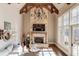 Sunlit Gathering room features a stone fireplace, vaulted ceiling with exposed beams, and large windows at 922 Little Darby Ln, Suwanee, GA 30024