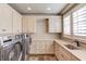 Laundry room with ample cabinet space and granite counters at 922 Little Darby Ln, Suwanee, GA 30024
