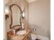 Stylish powder room with granite countertop and an arched mirror at 922 Little Darby Ln, Suwanee, GA 30024