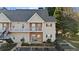 Multi-story townhome featuring beige siding, brick accents, a covered porch, and a well-maintained landscape at 1709 Bald Ridge Marina Rd # 4, Cumming, GA 30041