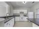 Modern kitchen with white cabinets, dark countertops, and stainless steel appliances at 1761 Stanwood Nw Dr, Kennesaw, GA 30152