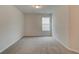 Simple carpeted bedroom with a window and neutral walls at 4331 Portsbrook Ave, Snellville, GA 30039