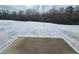 Snowy backyard with patio and wood line in background at 771 Gelderland Dr, Hampton, GA 30228